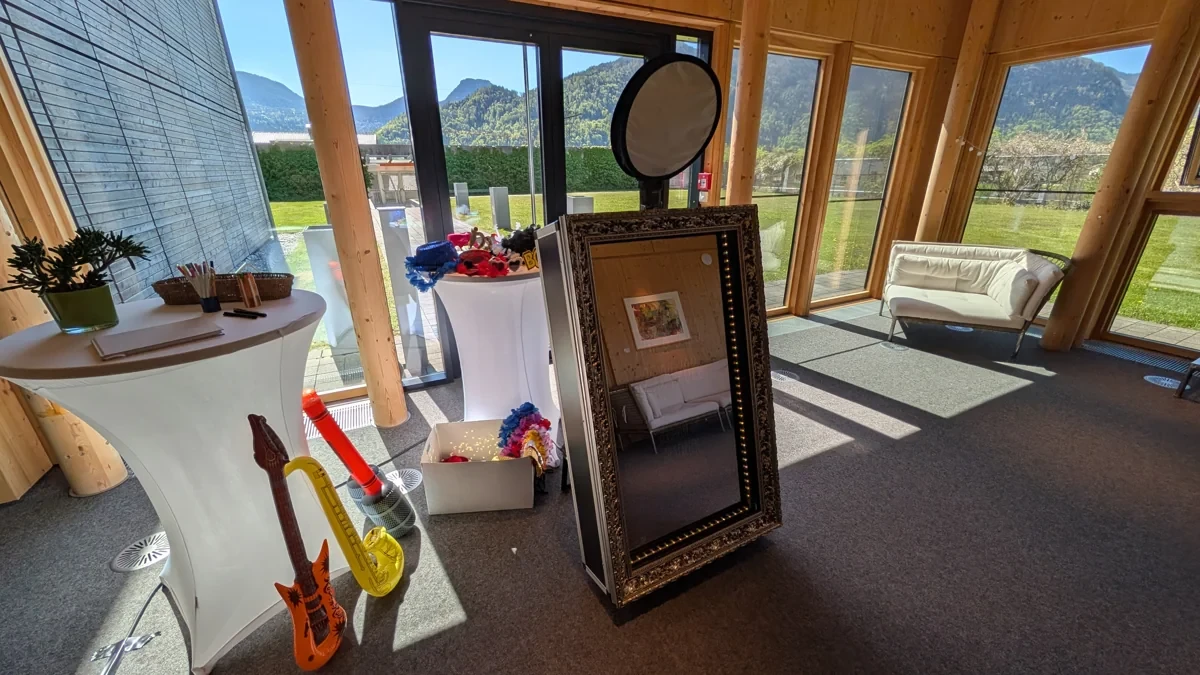 Fotospiegel und Requisiten in einer lichtdurchfluteten Eventlocation mit Bergblick.