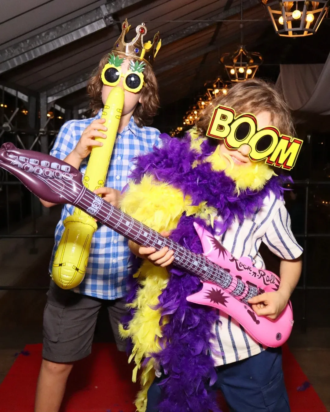 Kinder mit Gitarre, Federboa und Spaßbrille vor dem Fotospiegel