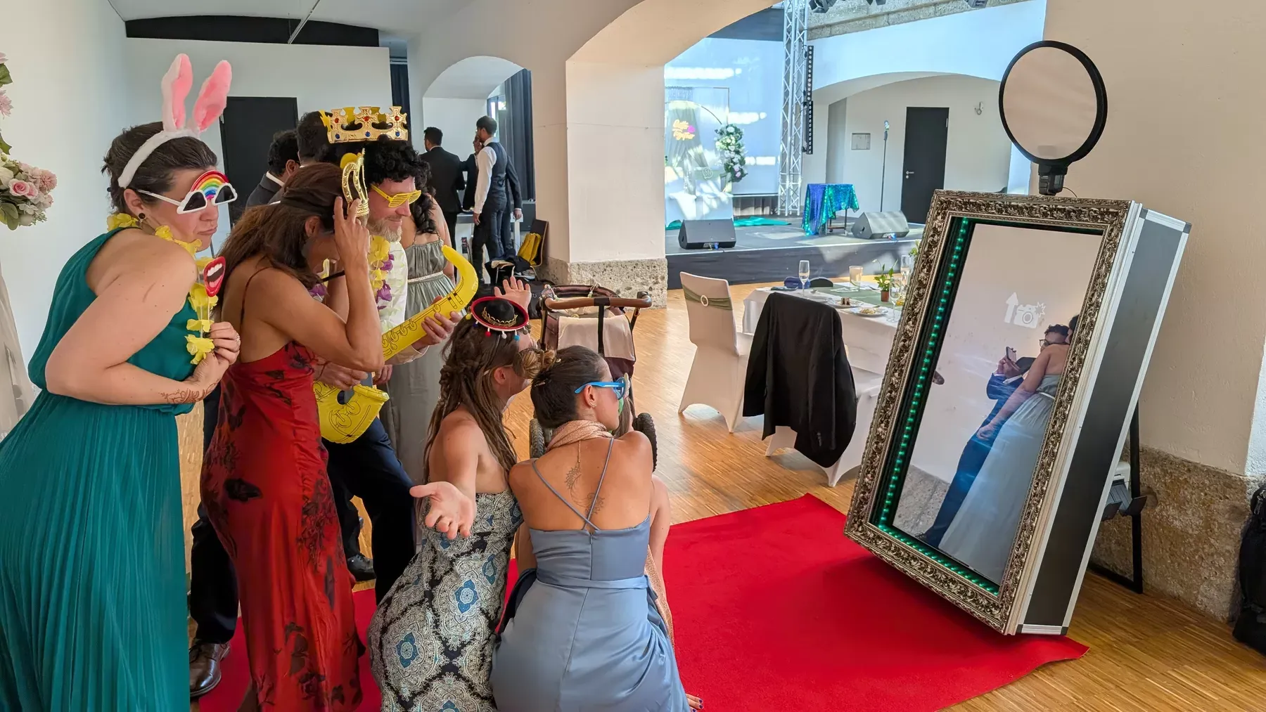 Hochzeitsgäste posieren mit Accessoires vor dem Fotospiegel