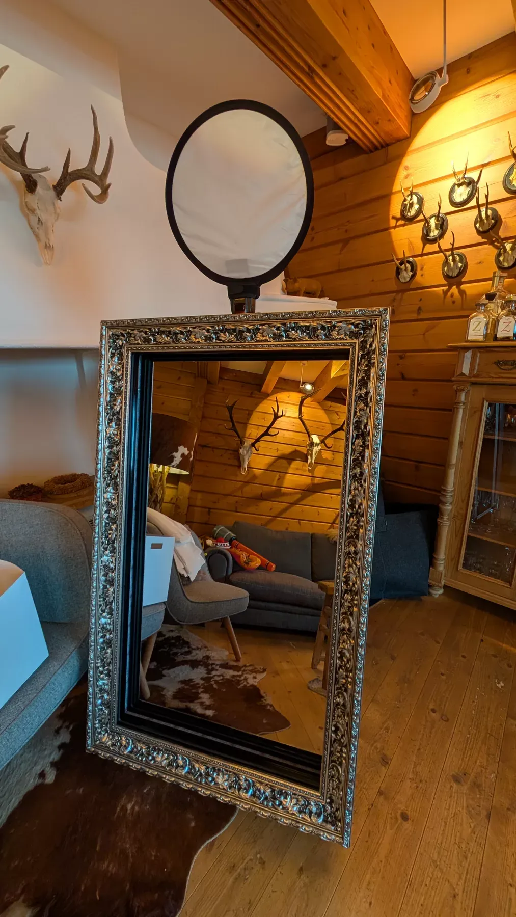 Der Fotospiegel in einer Berghütte mit Geweihen an der Wand